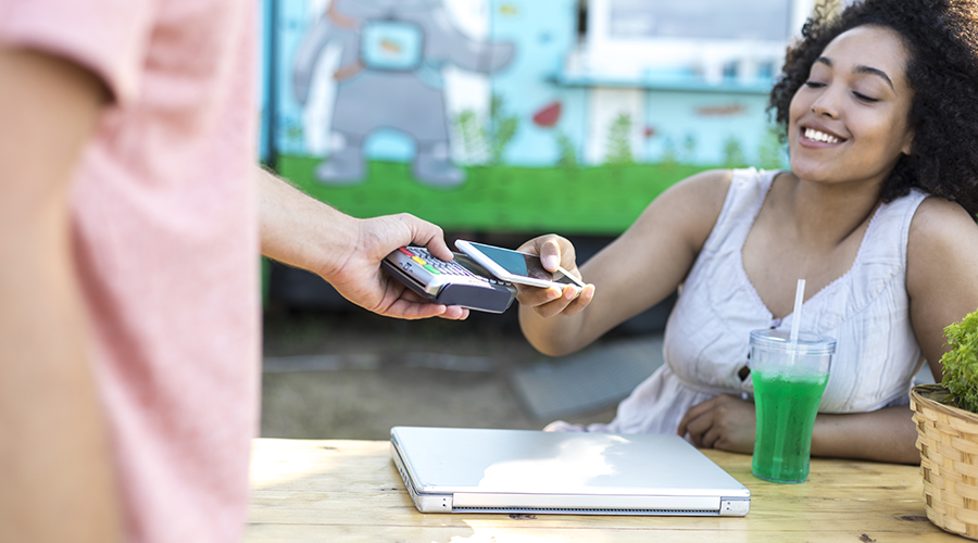 Young lady using mobile phone to make payment