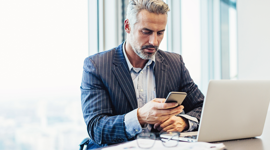 Mature professional male checking account via mobile phone