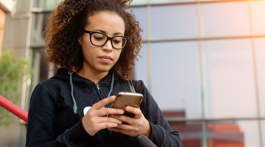 Young female checking account via mobile phone