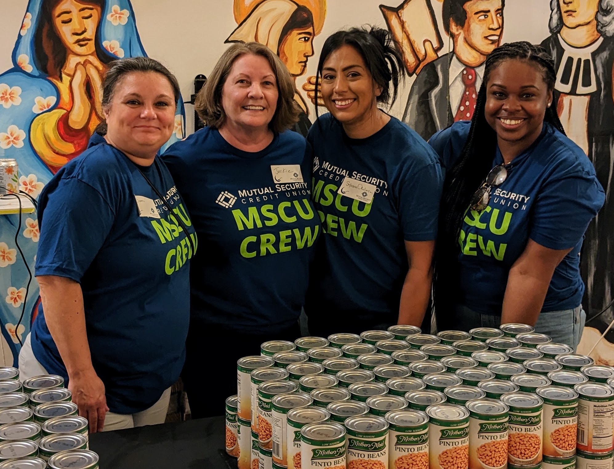 MSCU employees at fundraiser with cans in front of them