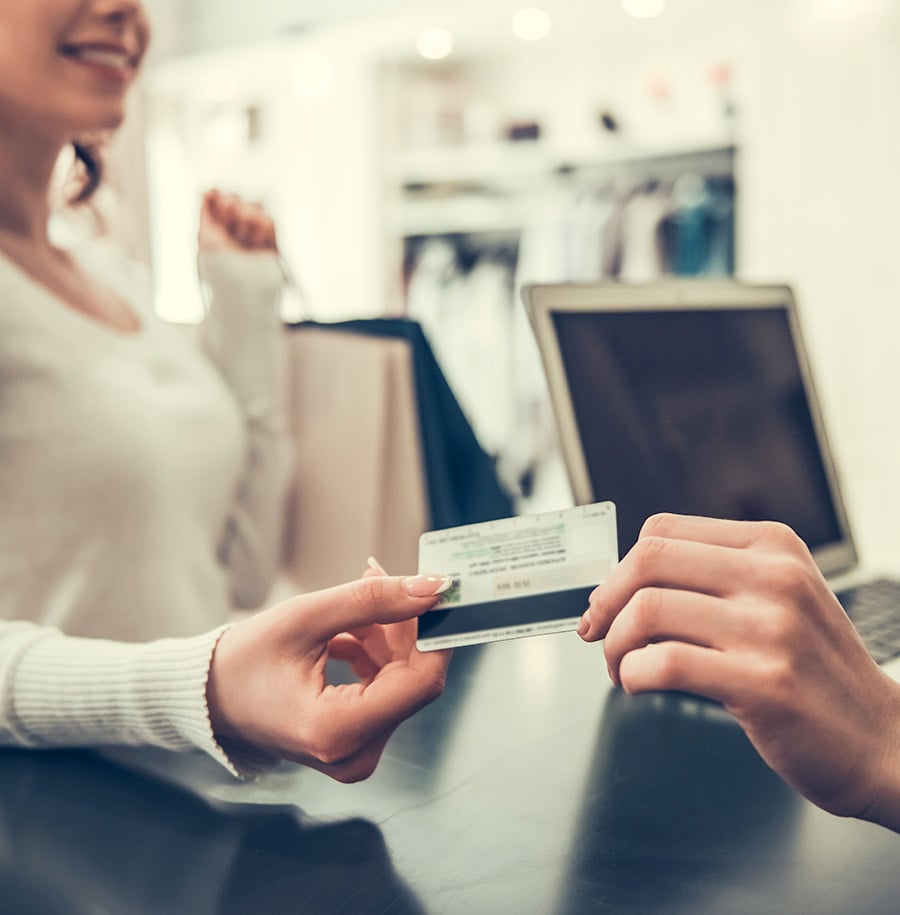 woman paying with card at retail clothing sore