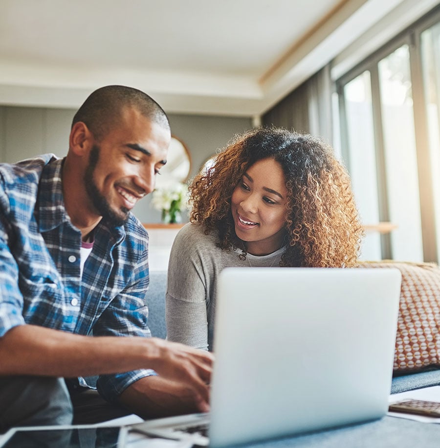 Happy couple having a discussion over a laptop